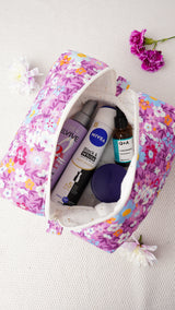 Floral-patterned makeup bag with skincare products on a light background
